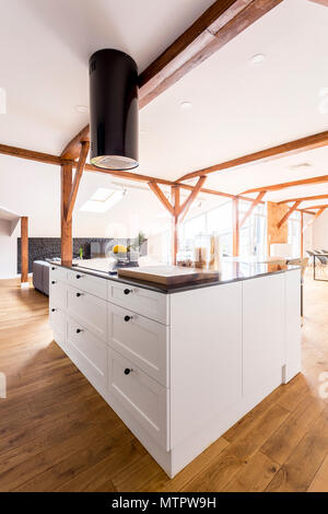 https://l450v.alamy.com/450v/mtpw9h/side-view-of-white-classic-kitchen-island-with-black-glossy-countertop-in-spacious-apartment-with-wooden-floor-mtpw9h.jpg