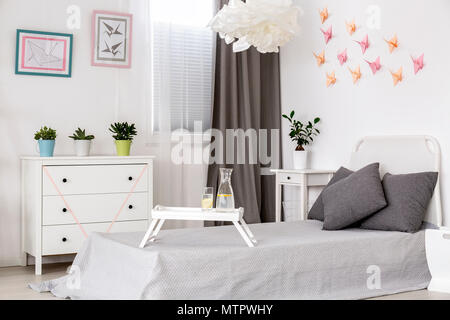 Bedroom in white with grey details and creative origami wall decor Stock Photo