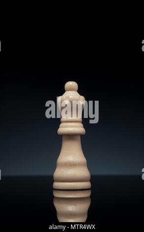 Chess queen, on gradient dark gray background. Portrait format. Stock Photo