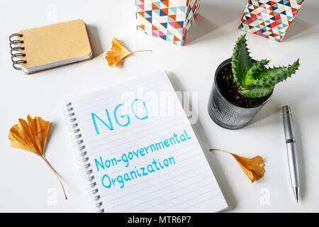 NGO Non-Governmental Organization written in a notebook on white table Stock Photo