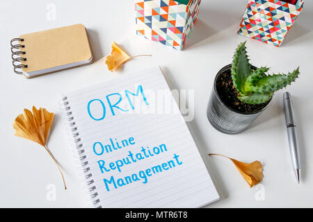 ORM Online Reputation Management written in a notebook on white table Stock Photo