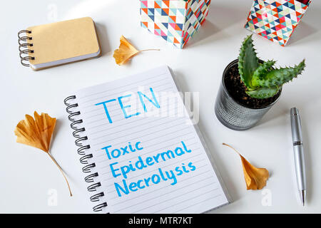 TEN- Toxic Epidermal Necrolysis written in a notebook on white table Stock Photo