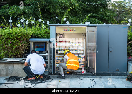Electricians at work in China, repairing circuits, wires and things Stock Photo