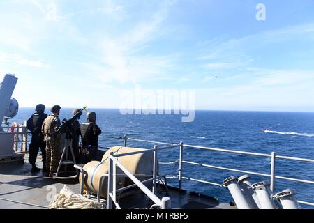 A fast patrol craft crew conducts weapons handling operations, loading ...