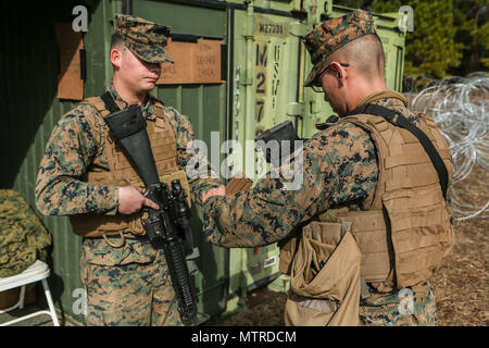 U.S. Marine Corps Lance Cpl. Yosef A. Charriez-Deleleon, left, Embarkation Specialist, Service Company, Combat Logistics Regiment (CLR) 2, 2nd Marine Logistics Group (MLG), and Lance Cpl. Nicolas J. Chairez, Chemical Biological Radiological Nuclear Specialist, Headquarters Company, CLR-2, 2nd MLG, perform the proper duty change over procedures during a command post exercise (CPX) at Landing Zone Canary on Camp Lejeune, N.C., Jan. 18, 2016. CLR-2 conducted the CPX in preparation for an upcoming deployment. (U.S. Marine Corps photo by Lance Cpl. Tyler W. Stewart) Stock Photo