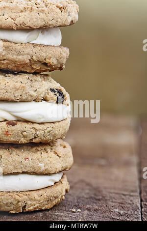 Macro stack of carrot cake raisin cookies sandwiches stuffed with cream cheese icing. Free space for copy text background. Stock Photo