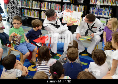180524-N-RE636-0023 BROOKLYN, N.Y. (May 24, 2018) Fire Controlman 2nd Class Brian Keenan, from Philadelphia, and Electrician's Mate 2nd Class Kyle Finlay, from Merritt Island, Florida, read to children at the Brooklyn Public Library during Fleet Week New York 2018. Both Sailors are attached to the guided-missile destroyer USS Mitscher (DDG 57) based at Norfolk, Va. Now in its 30th year, Fleet Week New York is the city’s time-honored celebration of the sea services. It is an unparalleled opportunity for the citizens of New York and the surrounding tri-state area to meet Sailors, Marines and Coa Stock Photo