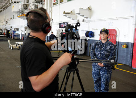 180522-N-PX557-055  NORFOLK, Va.  (May 22, 2018)  Aviation Ordnanceman 2nd Class Gabriella Koestel, assigned to USS George H.W. Bush (CVN 77), provides an interview in the hangar bay for Naval Supply Systems Command (NAVSUP) Business Systems Center (BSC) as part of NAVSUP BSC’s Meet the Fleet event in the Hampton Roads, Va., area of operation, May 22. The four-day event was held May 21-24 and served as an opportunity for personnel to directly engage with Sailors serving in the area who use supply, logistic, and financial systems supported by NAVSUP BSC. The event also provided insight on how N Stock Photo