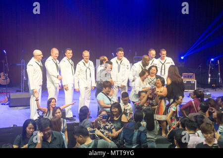 KOTA KINABALU, MALAYSIA (May 23, 2018) Members of the U.S. 7th Fleet Band take pictures with fans at the JKKN Sabah Complex in Kota Kinabalu, Malaysia after a performance. The band is supporting a U.S. 7th Fleet theater security cooperation mission and will be traveling to several Indo-Pacific countries in the coming weeks. (U.S. Navy photo by Mass Communication Specialist 2nd Class Chase Hawley/Released) Stock Photo