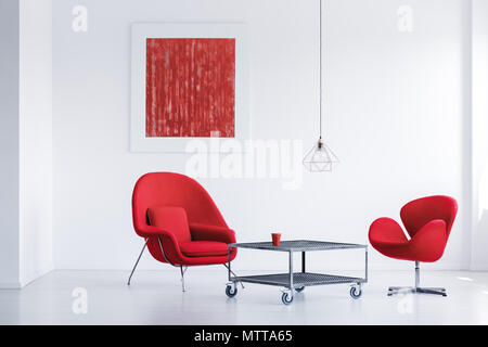 White simple waiting room with two red chairs by the industrial table Stock Photo