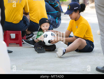 180524-N-FL910-0028  NHA TRANG, Vietnam (May 24, 2018) A Sailor currently deployed in support of Pacific Partnership 2018 (PP18), plays with a young child at Khanh Hoa Social Protection Center during a community event. PP18's mission is to work collectively with host and partner nations to enhance regional interoperability and disaster response capabilities, increase stability and security in the region, and foster new and enduring friendships across the Indo-Pacific Region. Pacific Partnership, now in its 13th iteration, is the largest annual multinational humanitarian assistance and disaster Stock Photo