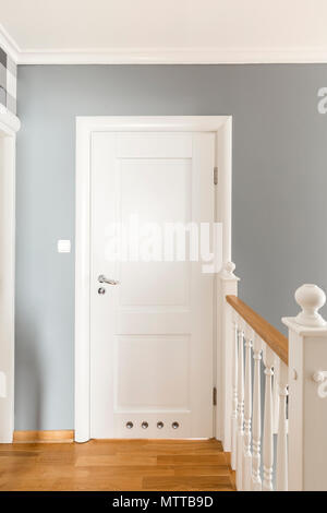 Grey corridor with white doors and simple wooden balustrade Stock Photo