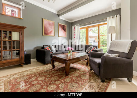 Spacious living room with big window, antique furniture and decorative wool carpet Stock Photo