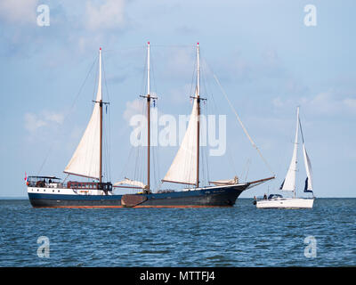 Authentic sailing ship, schooner, sailing very close to small sailboat on lake IJsselmeer, Netherlands Stock Photo