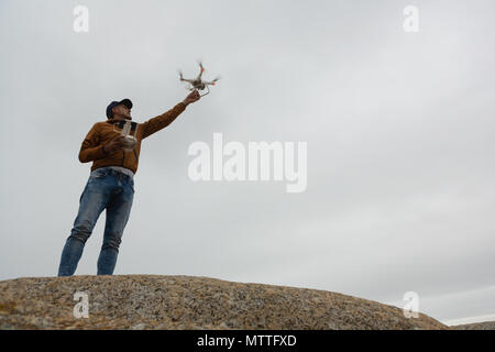 Man operating a flying drone Stock Photo