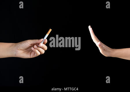 World No Tobacco Day, May 31. Just say NO to STOP Smoking. Close up Man  hand Reject cigarette offer on black background Stock Photo