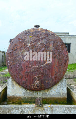 Smiley face drawn or graffitied on an old rusty oil tank Stock Photo