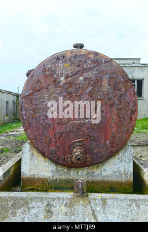 Smiley face drawn or graffitied on an old rusty oil tank Stock Photo