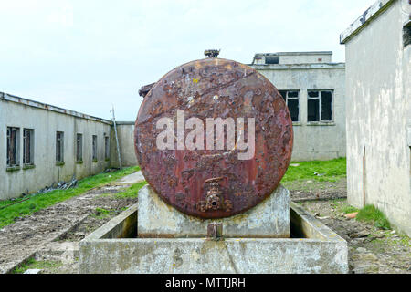 Smiley face drawn or graffitied on an old rusty oil tank Stock Photo