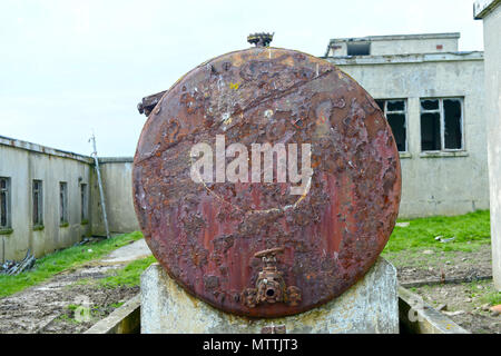 Smiley face drawn or graffitied on an old rusty oil tank Stock Photo