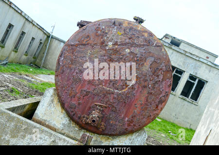 Smiley face drawn or graffitied on an old rusty oil tank Stock Photo