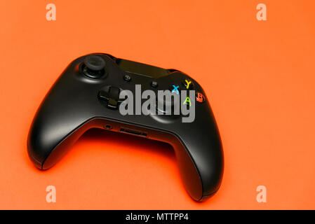 Black joystick on orange textured background. Computer gaming competition videogame control confrontation concept Stock Photo