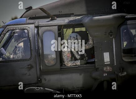 New Jersey Army National Guard Staff Sgt. John Panepinto, a UH-60L Black Hawk helicopter crew chief from the 1st Assault Helicopter Battalion, 150th Aviation Regiment sits in the gunner seat for a flight at Joint Base McGuire-Dix-Lakehurst, N.J. May 15, 2018, May 15, 2018. (U.S. Air National Guard photo by Master Sgt. Matt Hecht). () Stock Photo