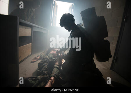 U.S. Soldiers taking part in the Region One Best Warrior Competition train the way they fight at Westhampton Beach, N.Y., April, 26, 2017. Fourteen Soldiers are competing in the three-day event, which features timed events, including urban warfare simulations, a 12-mile ruck march, land navigation, and the Army Physical Fitness Test. Stock Photo