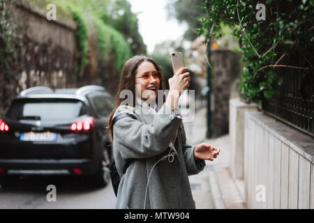 beautiful young girl takes photos on a smartphone Stock Photo