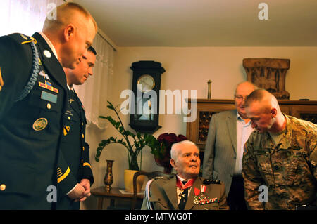 Staff Sgt. Tomasz Sobota, an infantryman working as a Polish linguist, assigned to 3rd Armored Brigade Combat Team, 4th Infantry Division greets Polish army retired Lt. Col. Jan Kudla, along with Command Sgt. Maj. Christopher Gunn and Col. Christopher Norrie, command team of 3rd ABCT, 4th ID during a visit to Kudla’s home to show their respect for his dedication and sacrifice to his country while serving in the Polish army during World War II, Jan. 31, 2017, in Zielona Gora, Poland.  Kudla joined the Polish army as an officer in 1941 and fought in battles in France, Germany, Belgium and the Ne Stock Photo