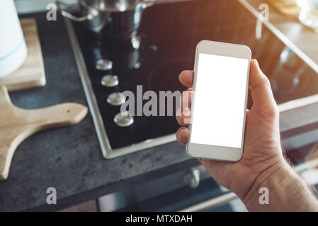 Internet of things, smartphone mock up screen in male hand. Smart home kitchen appliance connecting with mobile phone and exchanging data Stock Photo