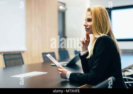 Attractive businesswoman using digital tablet in office Stock Photo