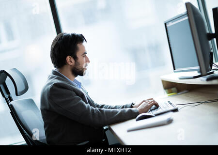 Portrait of young businessman working on computer Stock Photo