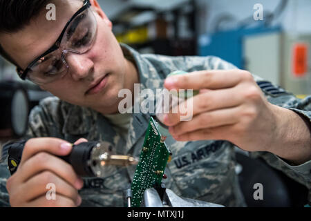 A technician from the 23d Maintenance Group Air Force Repair Enhancement Program at Moody Air Force Base, Georgia, solders components on a circuit board to repair equipment that standard units cannot fix. AFREP missions focus on diagnosing faults, repairing avionics, and extending the operational lifespan of aircraft systems. This training ensures Airmen are proficient in electronic repairs, enhances battlefield readiness, supports Air Combat Command missions, and contributes to the operational efficiency and maintenance capability of U.S. Air Force assets. Stock Photo