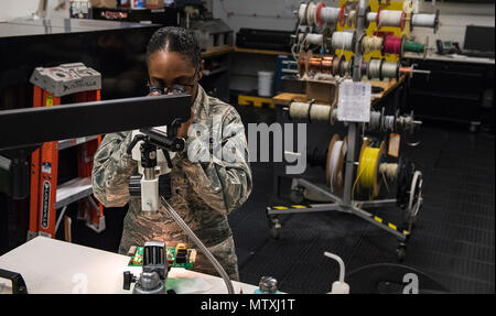 A technician from the 23d Maintenance Group Air Force Repair Enhancement Program at Moody Air Force Base inspects microscopic components on a circuit board. AFREP repairs recoverable parts, saving millions, and extend equipment life for U.S. Air Force aircraft. Technicians diagnose faults, repair electronics, and test circuit boards to maintain operational readiness. This work supports Air Combat Command missions, enhances technical proficiency of Airmen, and ensures mission-ready avionics and system reliability across Air Force units. Stock Photo