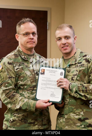 Spc. Seth Ravid(Right) with 4th Battalion, 7th Special Forces Group  (Airborne) poses with Sgt. Maj. William Barr(Left) with United States Army  Special Operations Command after being awarded an Army Commendation Medal  during an AG Corps brief at the 7th SFG(A)'s Auditorium Jan. 27, 2017 on  Eglin Air Force Base, Florida. Spc. Ravid won the USASOC level AG Corps  Soldier of the Year competition at Fort Bragg and is slated to compete at  the Army-level competition at Fort Jackson in June. (U.S. Army photos by  Staff Sgt. Brian K. Ragin Jr.) Stock Photo