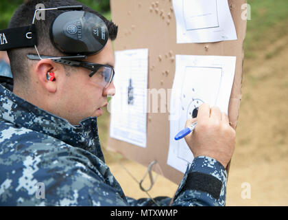 Va. (April 26, 2017) --  Gunner's Mate 3rd Class Zachary Perez, from San Antonio, Texas, assigned to Pre-Commissioning Unit Gerald R. Ford (CVN 78), marks bullet holes in a target at the Cheatham Annex (CAX) live-fire range on Naval Weapons Station Yorktown during in-port security force training. The CAX range is used year-round for pistol, rifle, and shotgun qualifications. Stock Photo