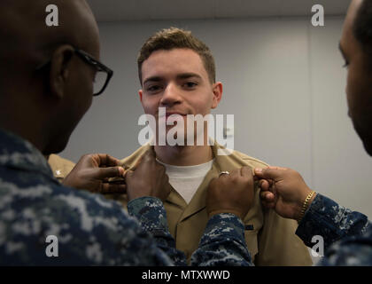 NEWPORT NEWS, Va. (Jan. 6, 2017) – Quartermaster 3rd Class Maxwell Clyburn, assigned to Pre-Commissioning Unit Gerald R. Ford (CVN 78), is frocked to the rank of petty officer third class by Chief Quartermaster Tyrone Anthony and Quartermaster 2nd Class Christian Rogers during a frocking ceremony. More than 170 Ford Sailors advanced from the September Navywide advancement exam. (U.S. Navy photo by Mass Communication Specialist 3rd Class Ryan Carter) Stock Photo