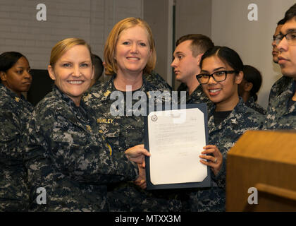 NEWPORT NEWS, Va. (Jan. 04, 2017) – Logistics Specialist 3rd Class Maria Delrosario, assigned to Pre-Commissioning Unit Gerald R. Ford (CVN 78), receives her frocking letter from Cmdr. Julie Treanor, Ford’s supply officer, and Ford’s command master chief Laura Nunley during a supply department frocking ceremony at Apprenticeship Hall.  More than 170 Ford Sailors advanced from the September Navy-wide advancement exam. (U.S. Navy photo by Mass Communication Specialist Seaman Joshua Murray) Stock Photo