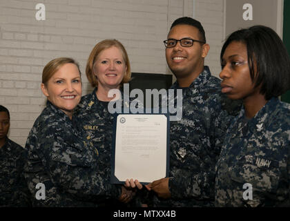 NEWPORT NEWS, Va. (Jan. 04, 2017) – Logistics Specialist 2rd Class Kevin Allen, assigned to Pre-Commissioning Unit Gerald R. Ford (CVN 78), receives his frocking letter from Cmdr. Julie Treanor, Ford’s supply officer, and Ford’s command master chief Laura Nunley during a supply department frocking ceremony at Apprenticeship Hall.  More than 170 Ford Sailors advanced from the September Navy-wide advancement exam. (U.S. Navy photo by Mass Communication Specialist Seaman Joshua Murray) Stock Photo