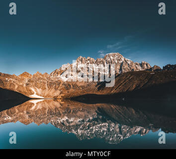 Wonderful panoramic view the Gokyo Lake on the mighty Himalayas mountains background. The protected area of the Sagarmatha National Park in the north-eastern Nepal. Stock Photo