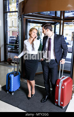 businesswoman entering hotel and talking by smartphone Stock Photo