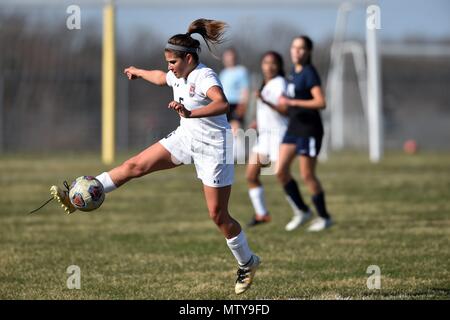 Player extending to keep a ball in play along a sideline and maintaining possession for her team. USA. Stock Photo