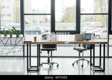 laptops on table in empty business office Stock Photo