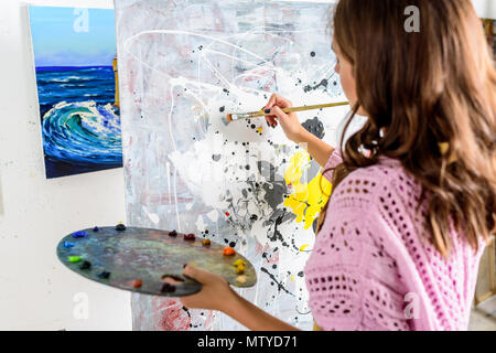 back view of female artist painting in workshop Stock Photo