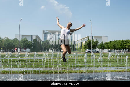 31 May 2018, Germany, Berlin: Johanna from Frankfurt jumping over the water fountains in front of the chancellery. Photo: Paul Zinken/dpa Stock Photo