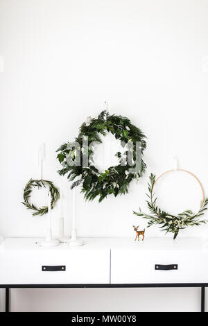Wreaths hanging on a wall by a sideboard