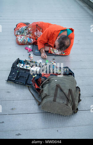 The chewing gum artist of London in action painting on Millennium bridge. Stock Photo