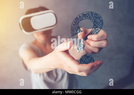 Woman with VR headset holding question mark, female person immersed in virtual reality Stock Photo
