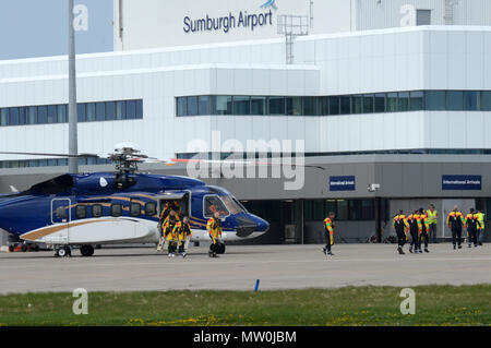 Offshore oil and gas workers travelling to and from work by helicopter to the oil rigs in the north sea at Sumburgh airport in Shetland Stock Photo